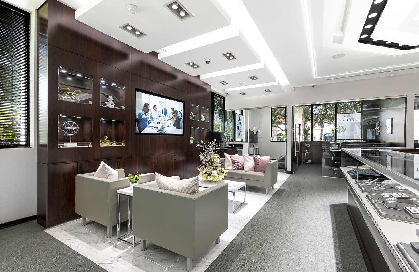 Diamonds Direct Diamonds Direct showroom lounge area with glass showcases featuring fine jewelry collections.