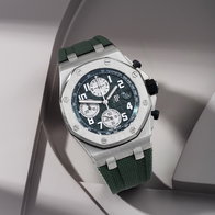 Stainless steel chronograph watch with green strap and octagonal bezel on a light background.